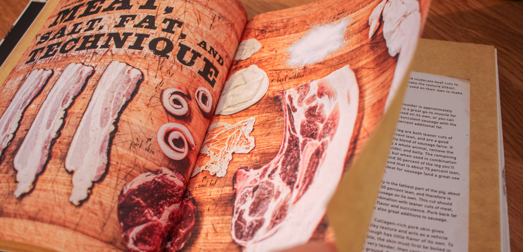 An open copy of our Sausage Making book with pictures of different cuts of meat and parts of the animal used for sausage making.  